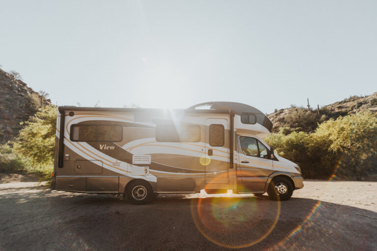 An RV parked with the sun shining behind it