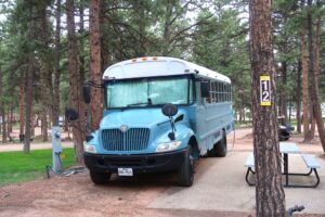 a blue school bus converted into a camper - Shutterstock