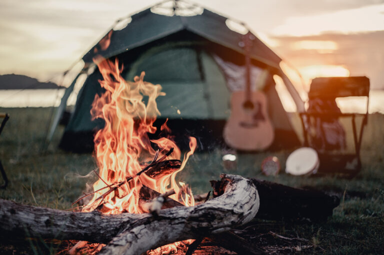 a campfire with a tent in the background