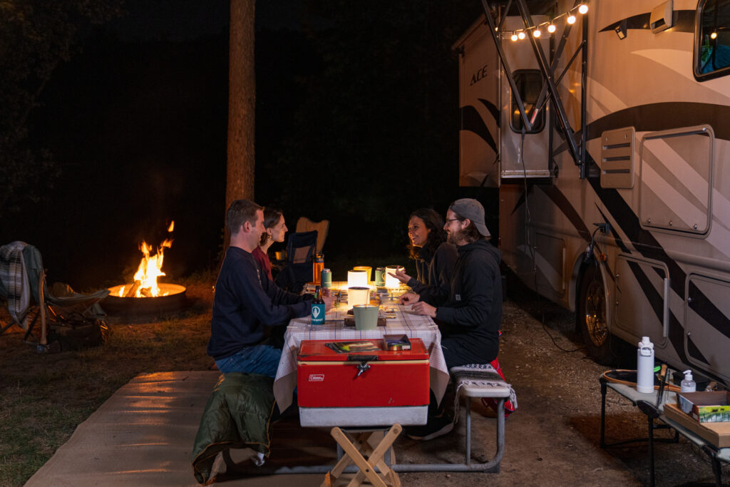 a family around a picnic table near an RV