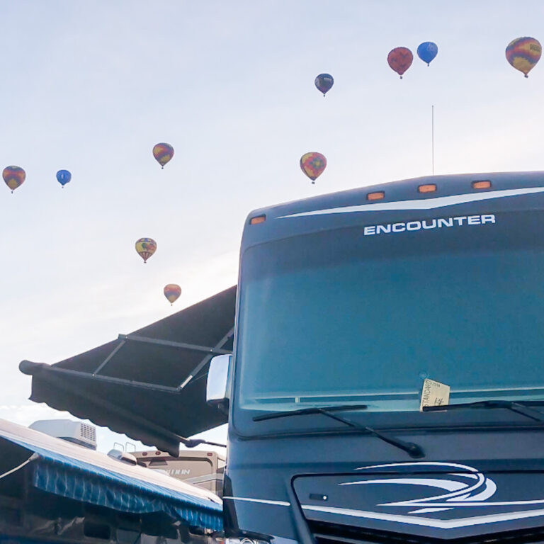 an RV awning with hot air balloons behind