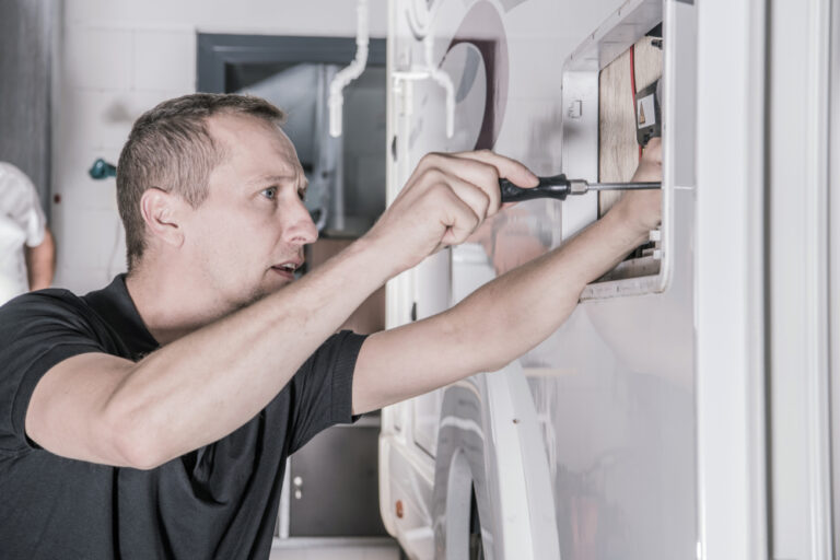 Man fixing RV refrigerator