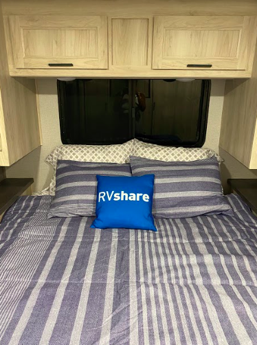 an RV bed with an RVshare pillow on it