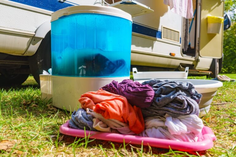 portable washing machine with folded clothes in the foreground