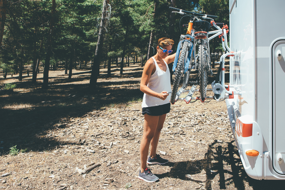 a woman taking bikes off an RV