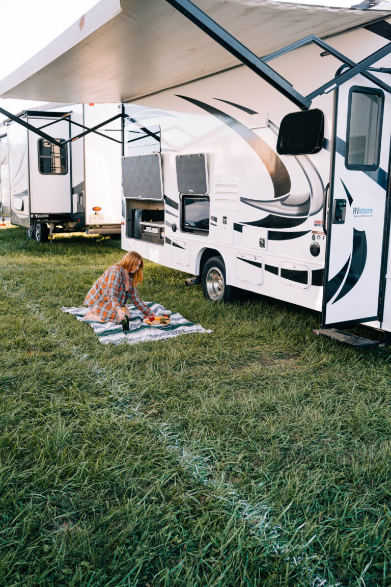 a woman on a blanket in front of an RV