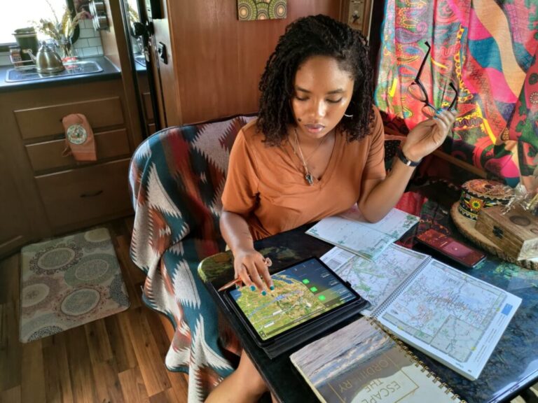 a woman planning a trip with maps and ipad