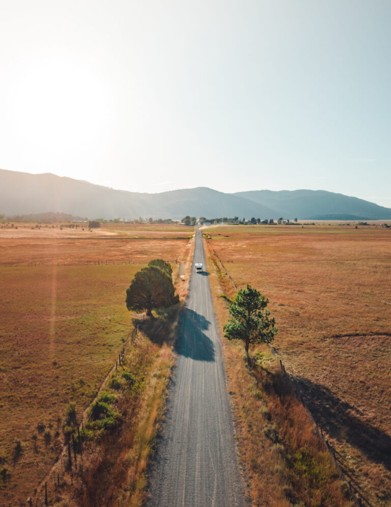 a long road with an RV driving on it