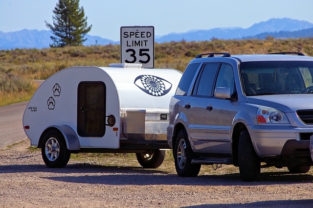 A teardrop camper being towed by a car
