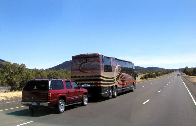 A Class A RV towing a car on a highway