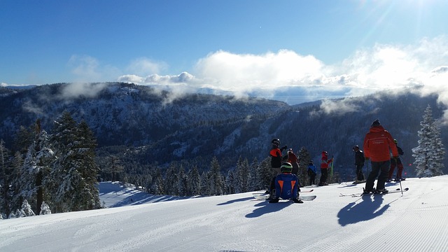 Skiers on a snowy mountain with blue skies behind them