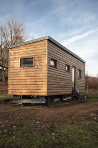 a tiny home on wheels, parked in a field