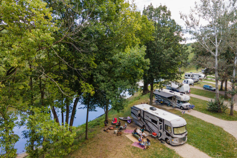 RVs parked in a campground next to a river
