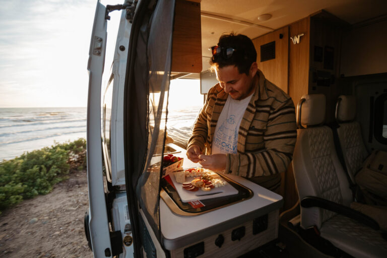 man in an RV cooking a meal
