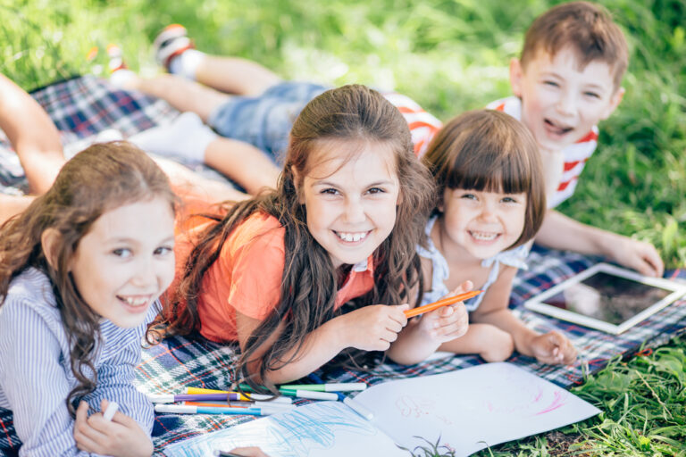 kids laying on the grass doing crafts