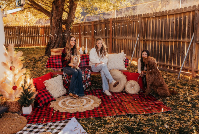 women sitting in a decorated space outside an RV