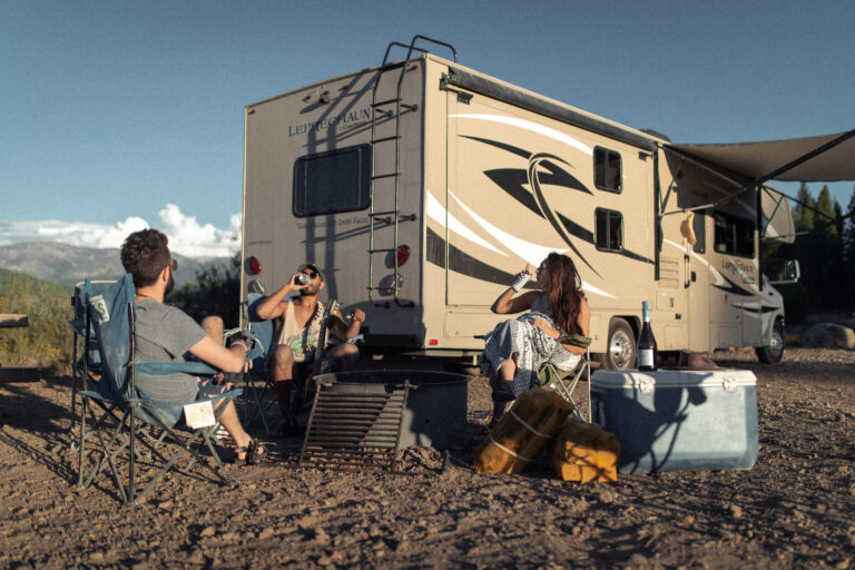 People relaxing and drinking outside an RV