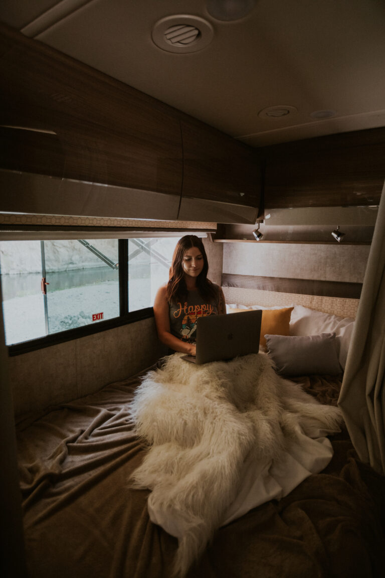 a woman on a laptop inside an RV