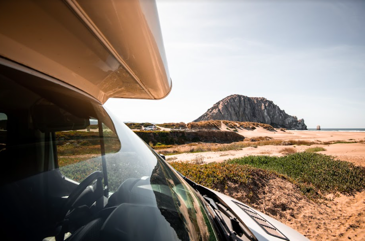 A close up of an RV window with mountains beyond