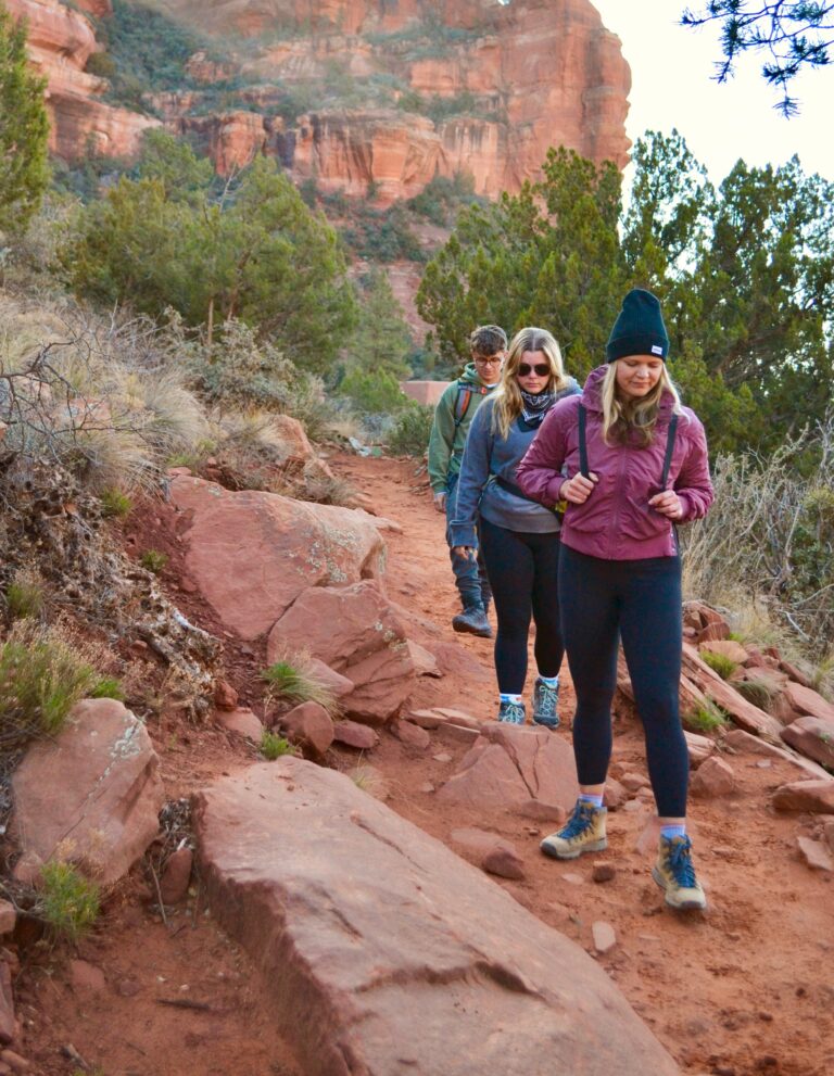 A group hiking near red rocks in the southwest