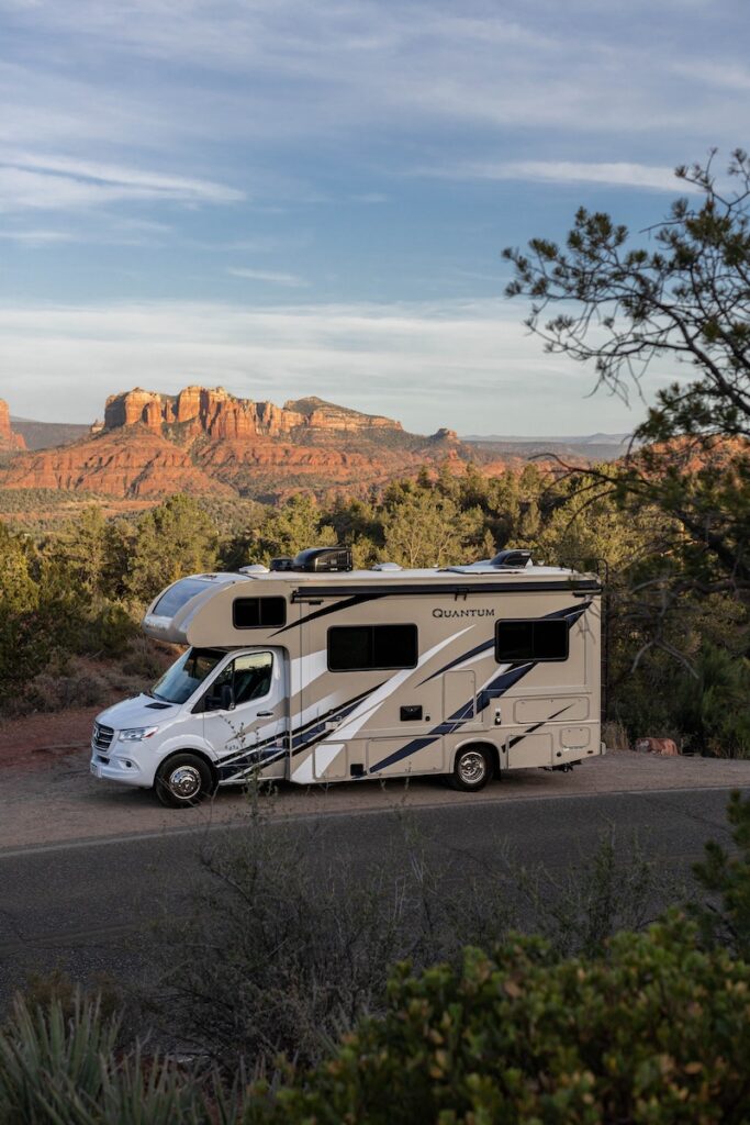 RV driving along road with mountain view background