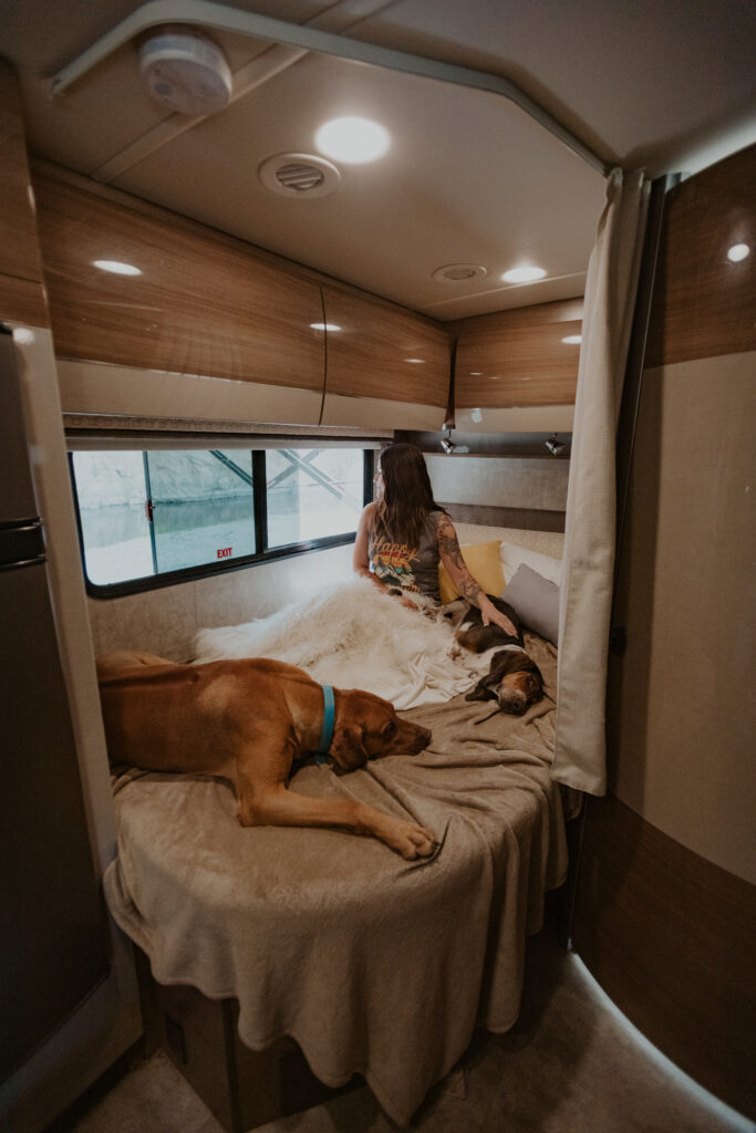 A woman and dog on an RV bed