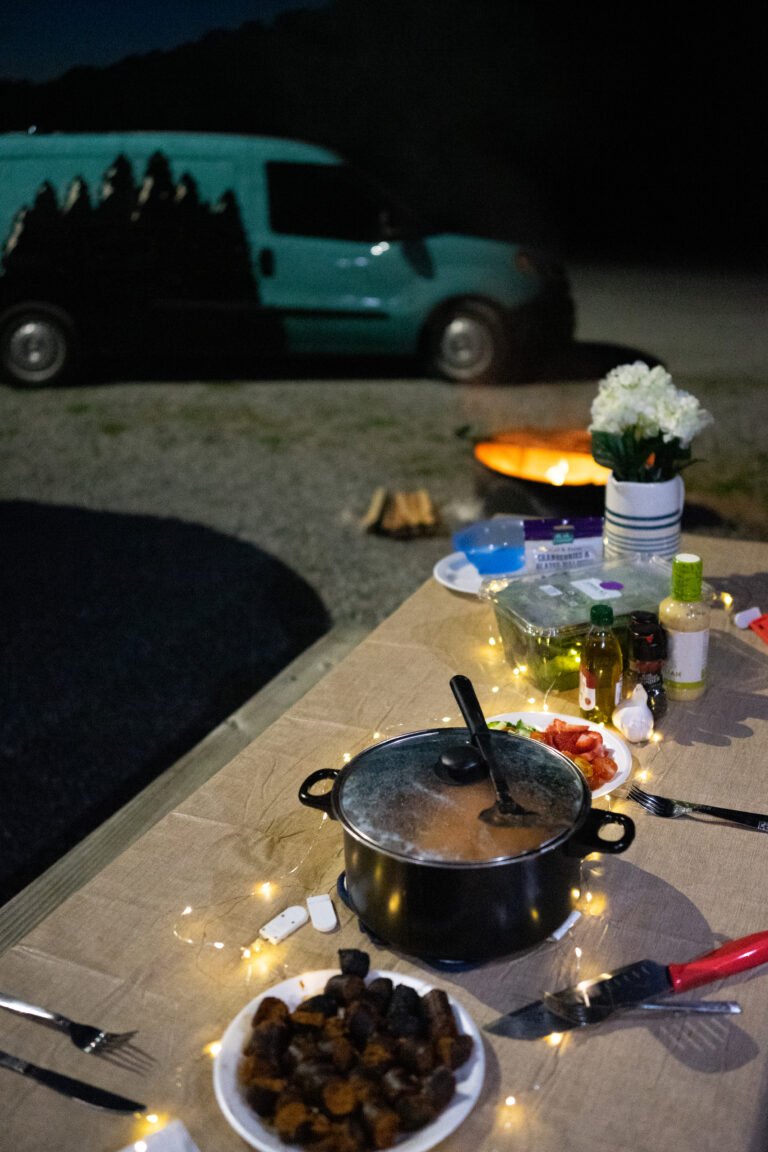 food set out on a picnic table next to an RV
