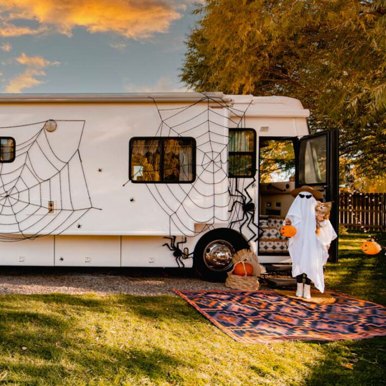 An RV with a spider web and Halloween decorations