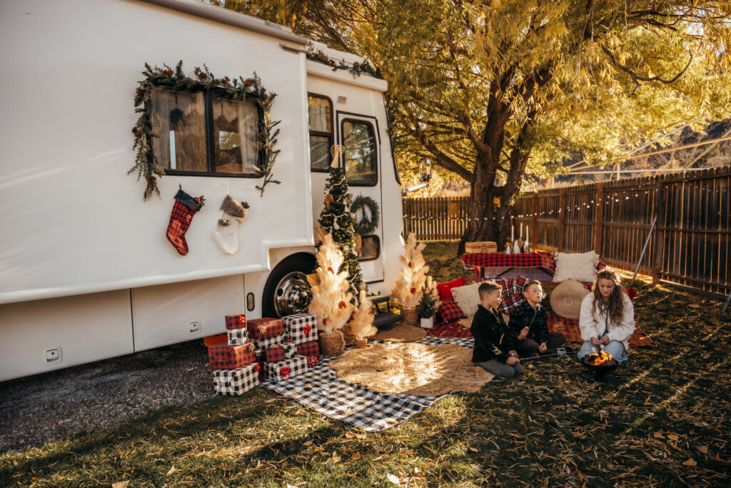 A family next to an RV decorated for Christmas