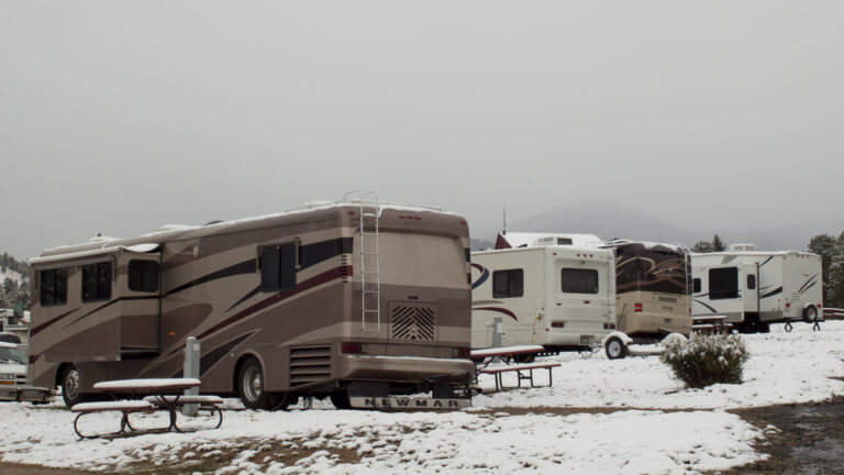 RVs parked at a campground in the snow