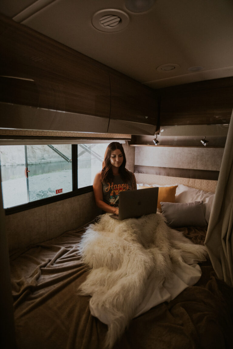 a woman on an RV bed on her computer