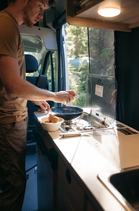 A man making eggs in an RV