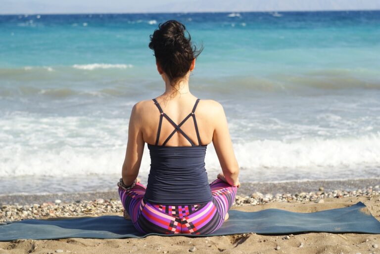 a woman practicing yoga on the beach