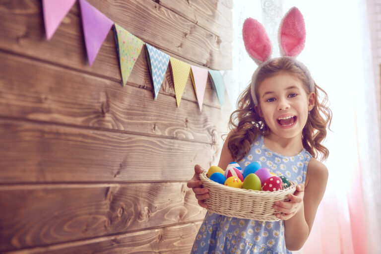 A girl in rabbit ears holding an Easter basket