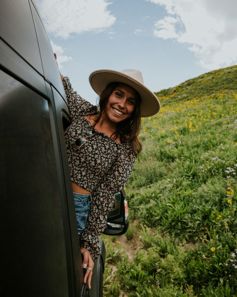 s woman hanging out the side of her campervan