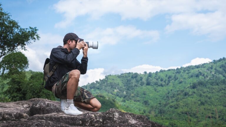 a man taking a picture in the mountains