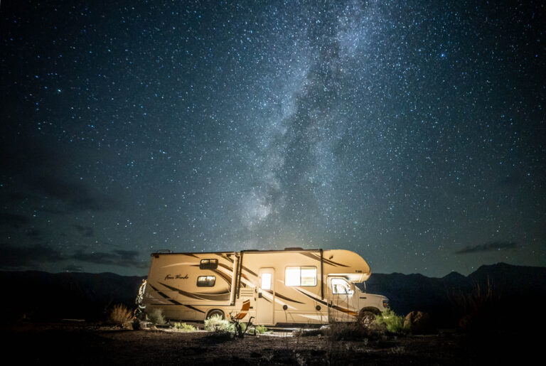 a camper at night with a sky full of stars