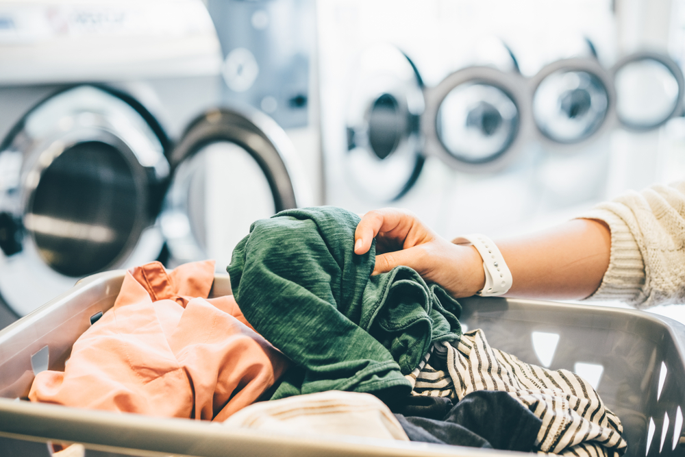 A person sorting clothes at laundromat