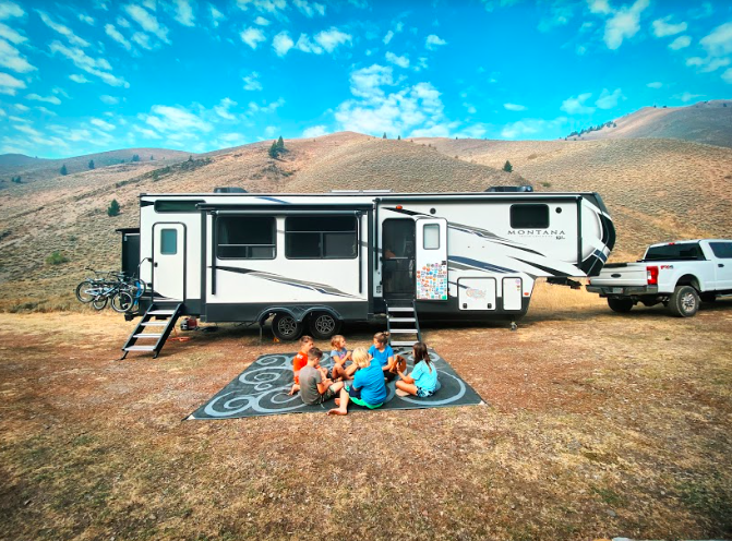 A fifth wheel trailer set up for camping