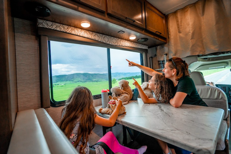 A mom and kids looking out an RV window
