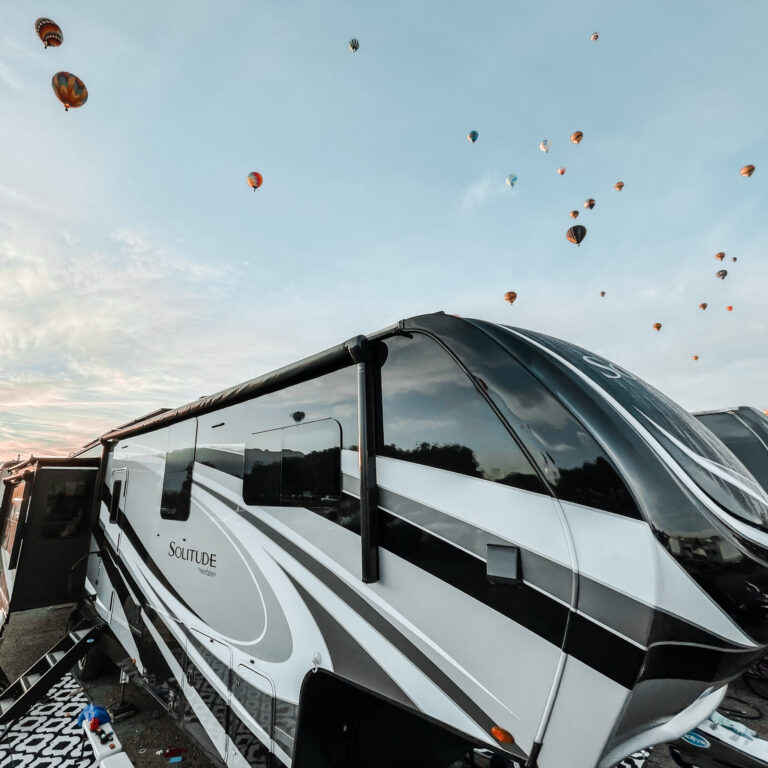 An RV trailer with hot air balloons behind