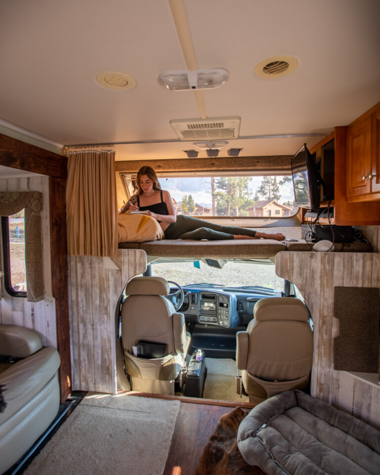 a woman relaxing on the top bunk in an RV