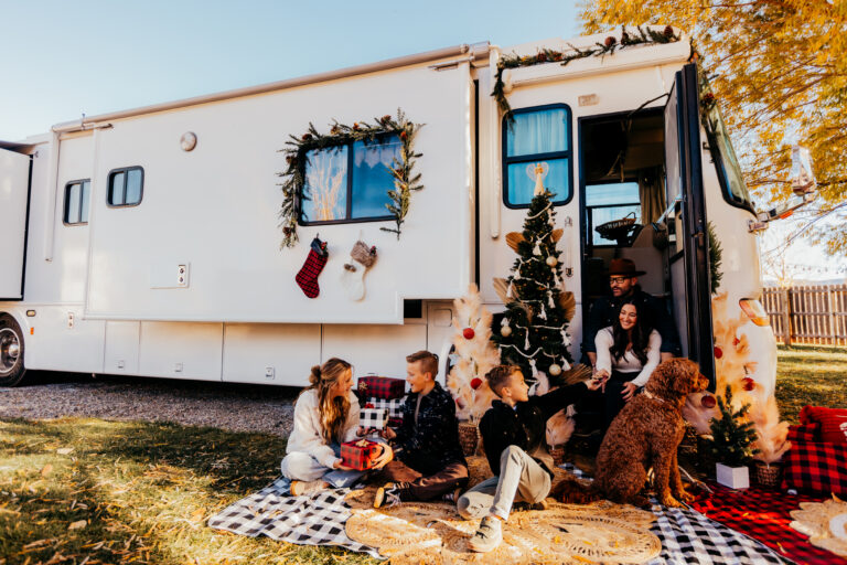 a family in front of an RV decorated for Christmas