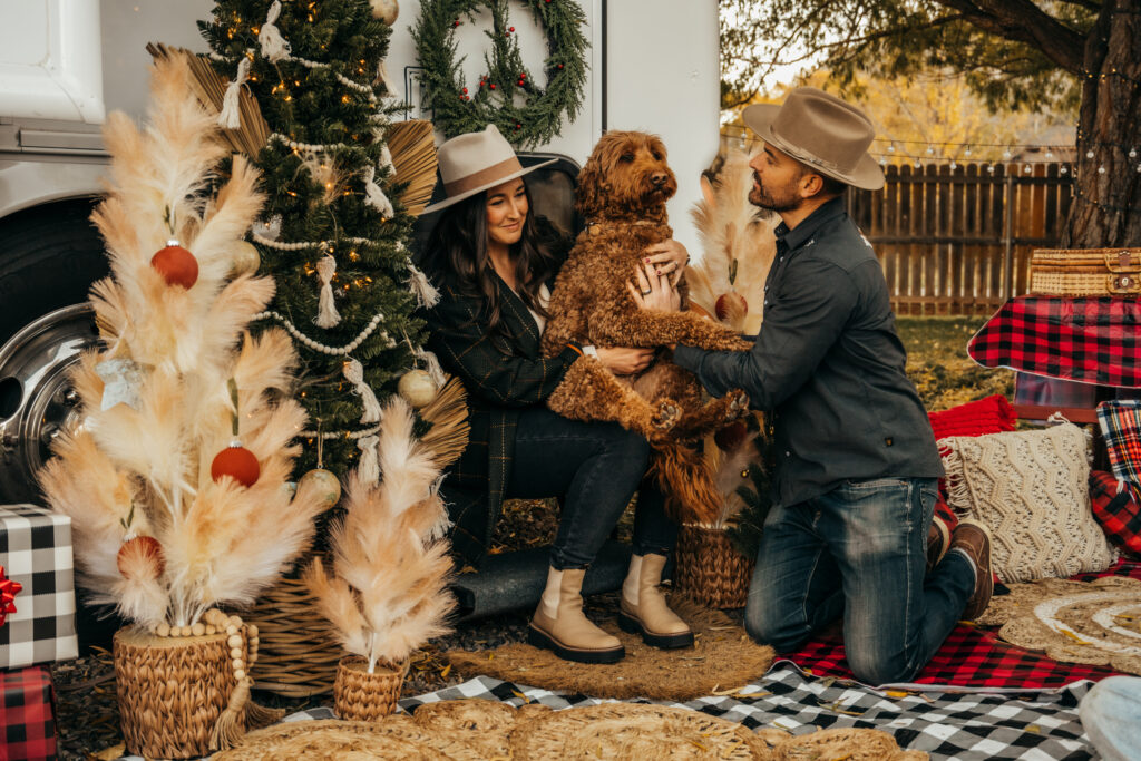a man, woman, and dog among holiday decorations