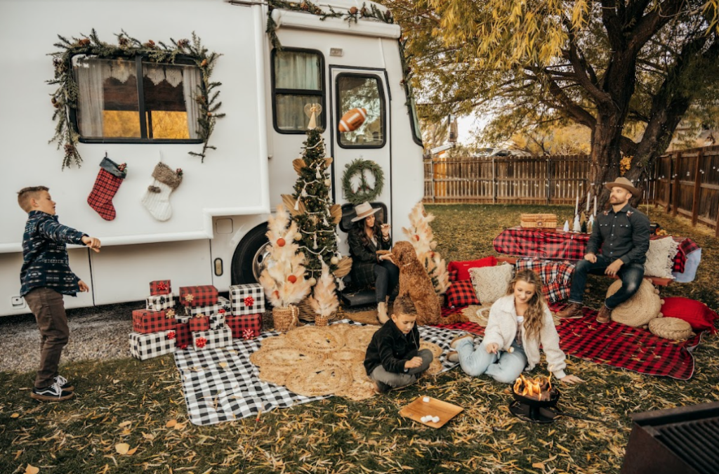 a family playing football near an RV decorated for Christmas