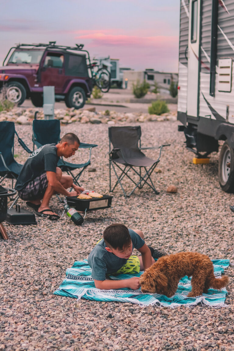 a family cooking and playing in front of an RV