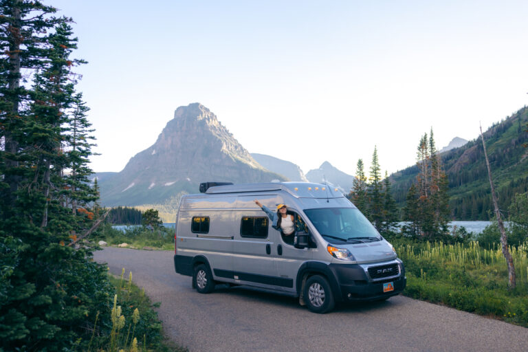 a woman leaning out the window of a campervan