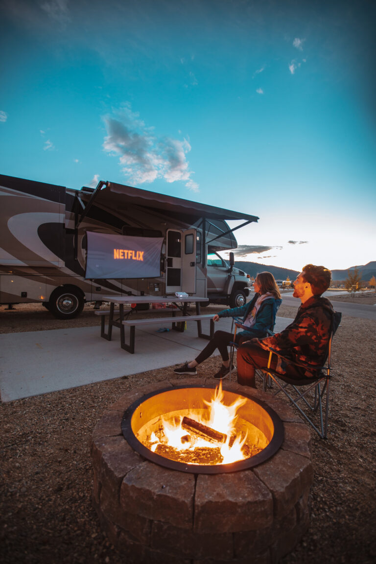a couple watching Netflix on the outside of their RV