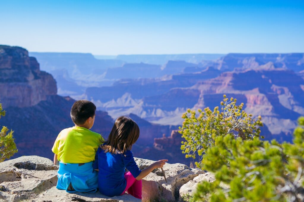 two kids looking over the Grand Canyon