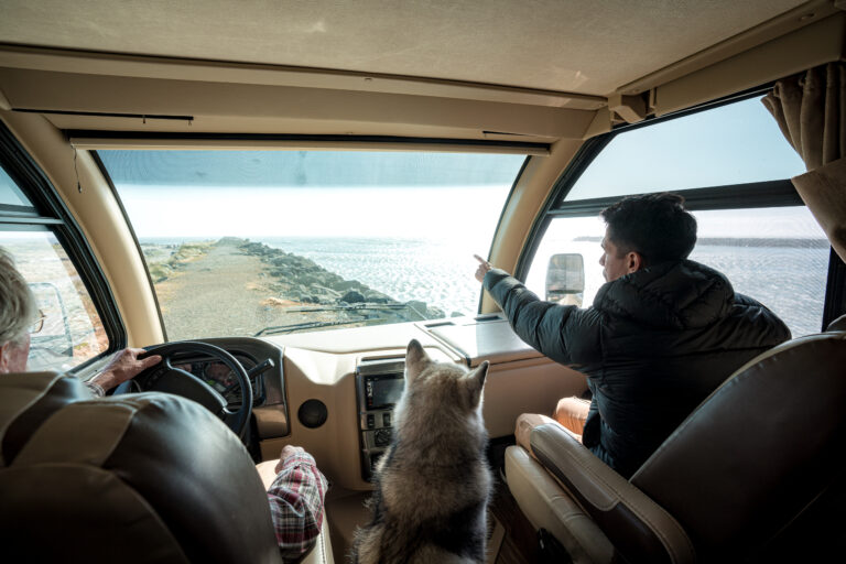 a man driving an RV with a passenger pointing out views